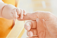 Baby holding finger with small hand